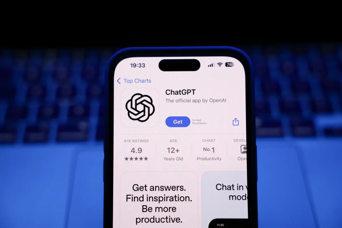 Экран смартфона с приложением ChatGPT на фоне клавиатуры ноутбука