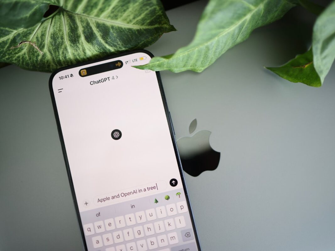 Смартфон с открытым приложением ChatGPT лежит рядом с ноутбуком