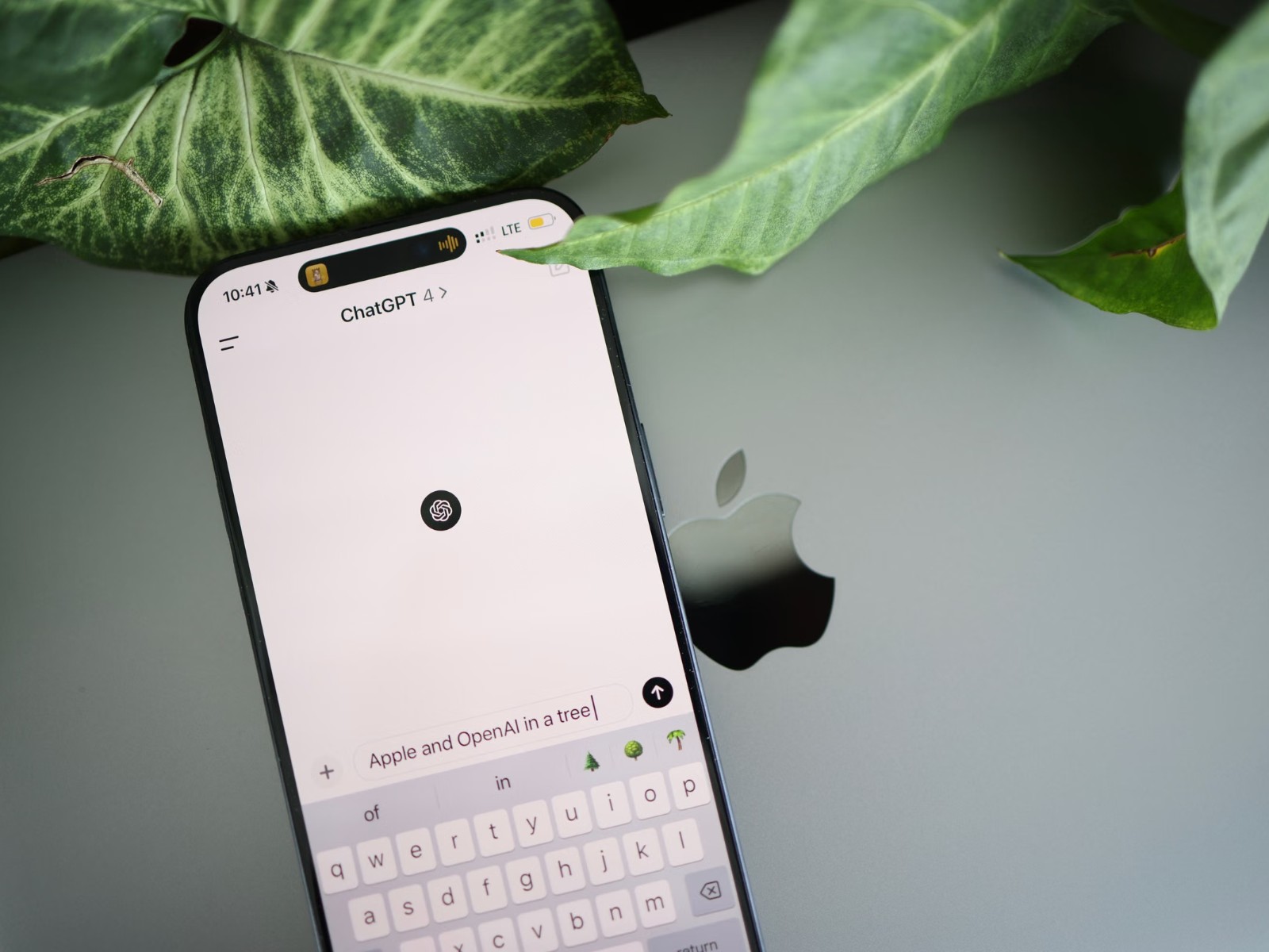 Смартфон с открытым приложением ChatGPT лежит рядом с ноутбуком