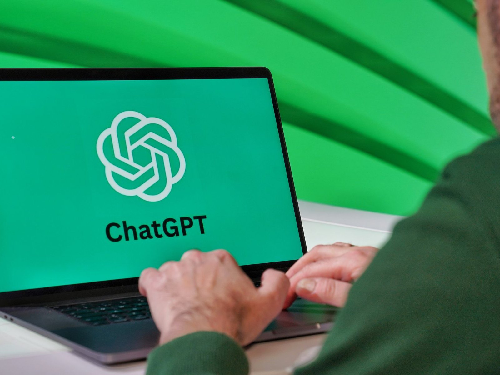 Человек за ноутбуком с логотипом ChatGPT на экране
