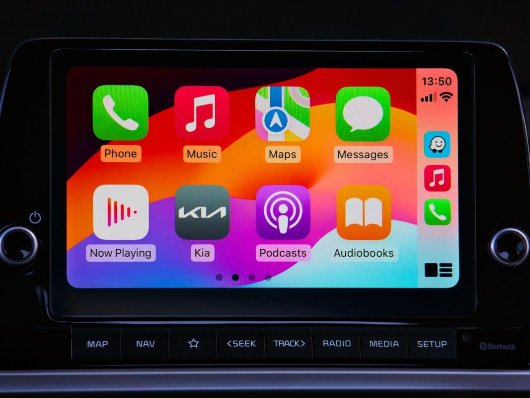 Главный экран Apple CarPlay с иконками приложений на сенсорном дисплее автомобиля Kia